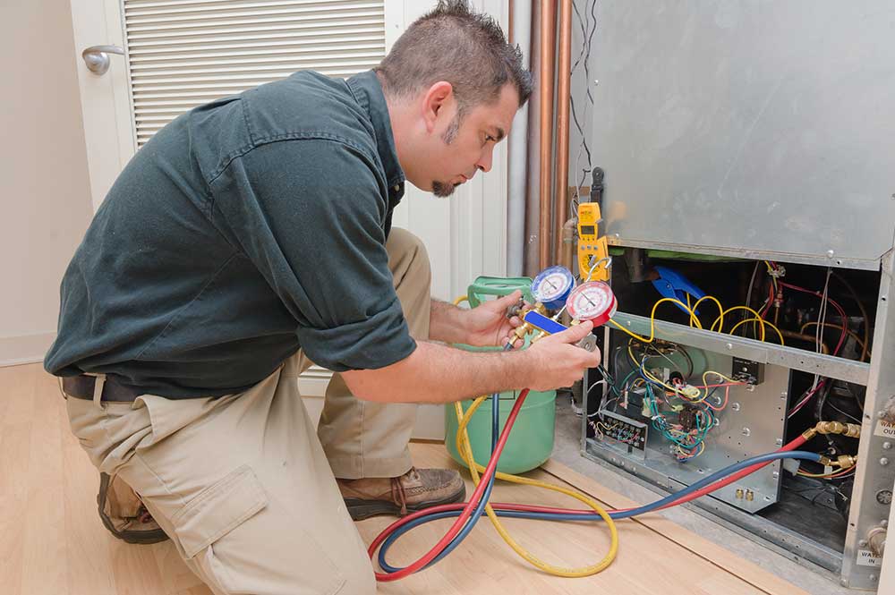 technician repairing furnace providing heater services